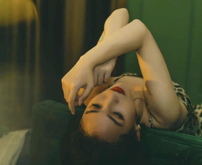 Sexy woman laying on her back with her head leaning backwards